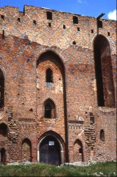 04 Schmuckformen beidseits der Portalnische im unteren Bereich. Über dem Tor die Stube des Hausvogtes. Aus dem Fenster der Windenkammer darüber lief die Zugkette des Fallgatters. Im granitenen Fenstersims zeigt sich noch heute die Reibungsspur.