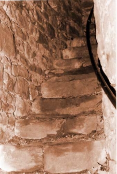 11 Die schmale Stiege im "Treppenhaus" der ansonsten massiven Schildmauer führt über 20 und nach einer Kehre über weitere 14 ausgestiefelte Steinstufen auf die Wehrplatte. Drei kleine Fenster, eins davon gegen den Burghof, spenden beidseits spärliche Helle.